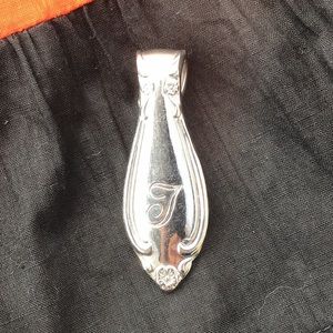 "T"monogrammed pendant.